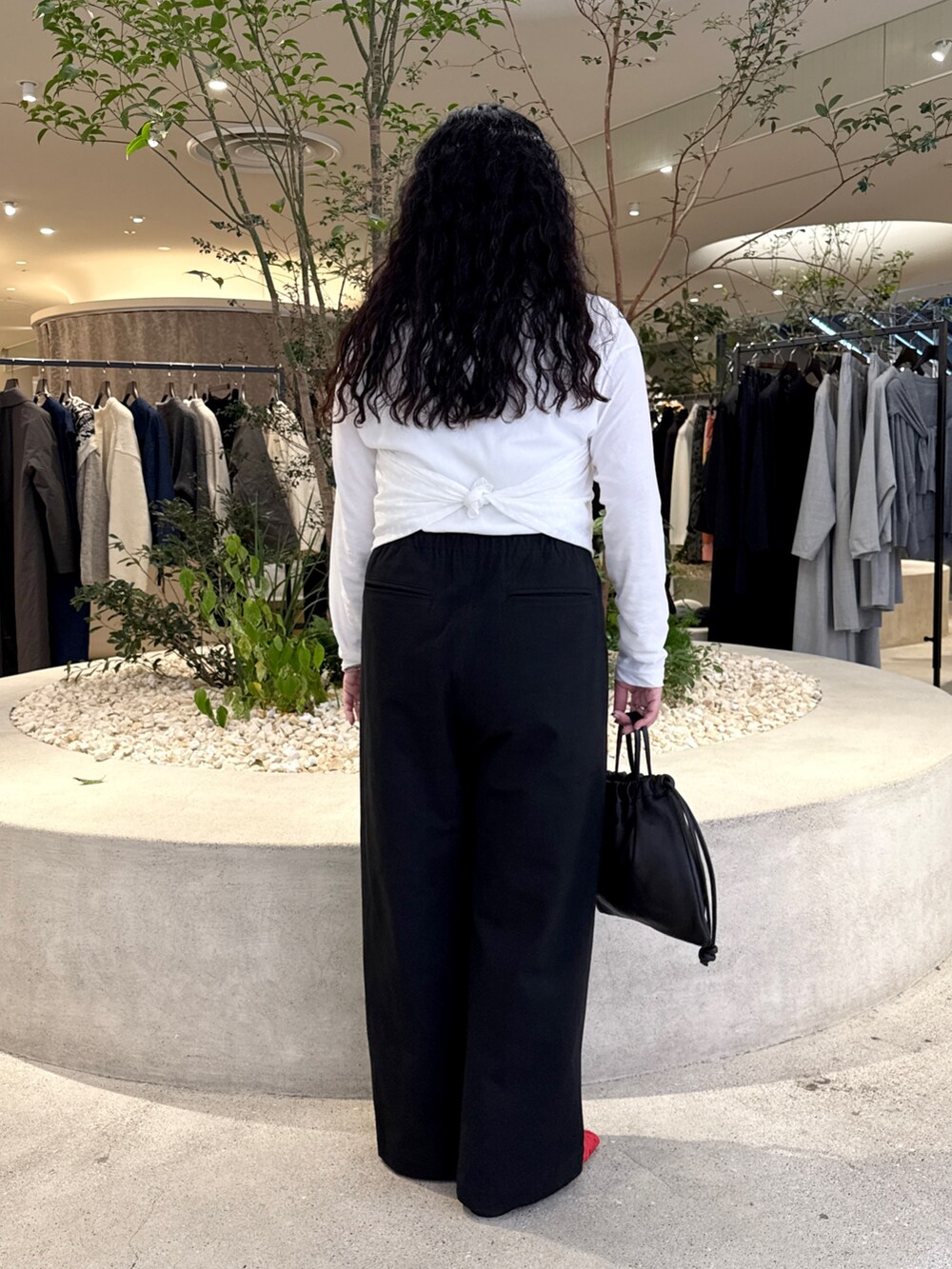 ホワイト系のTシャツ/カットソー、ブラック系のその他パンツ、ブラック系のバッグを着用したレディースの秋コーディネートの3枚目の写真