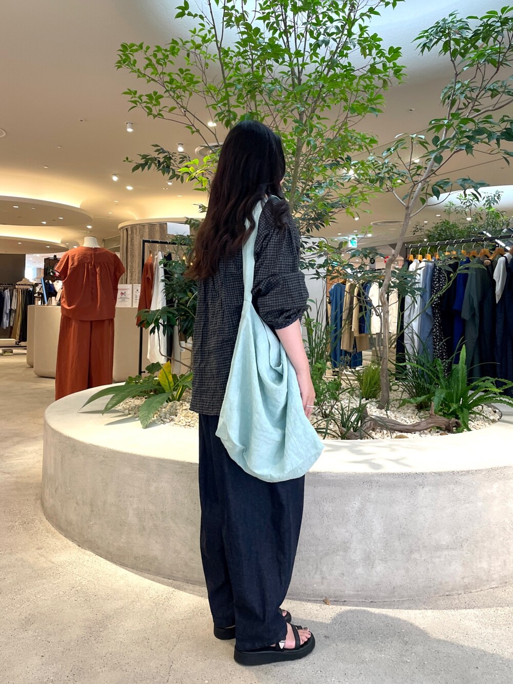 グリーン系のショルダーバッグ、ブルー系のデニムパンツ、ブラック系のシャツ/ブラウスを着用したレディースの夏コーディネートの2枚目の写真