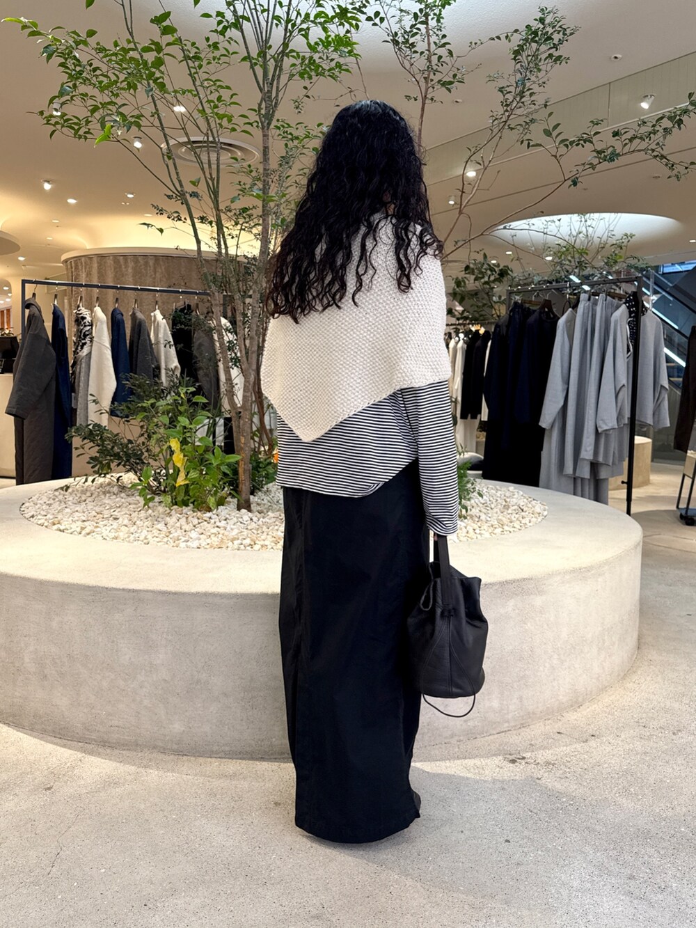 ブラック系のバッグ、ブラック系のTシャツ/カットソー、ブラック系のスカートを着用したレディースの秋コーディネートの3枚目の写真