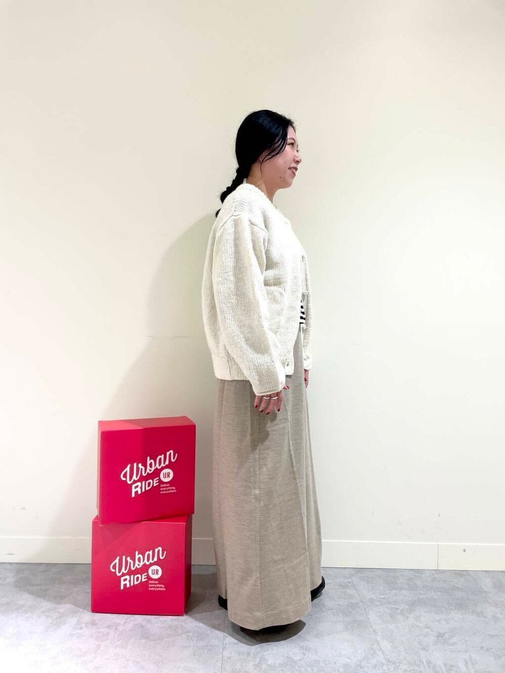 ホワイト系のニット/セーター、ブラック系のTシャツ/カットソー、ベージュ系のスカートを着用したレディースの冬コーディネートの4枚目の写真