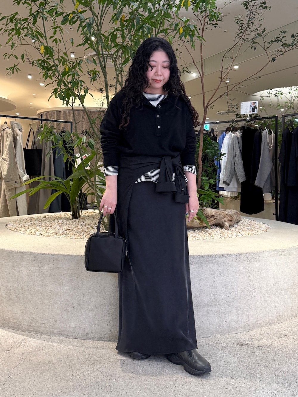 ブラック系のニット/セーター、ブラック系のTシャツ/カットソー、ブラック系のスカートを着用したレディースの冬コーディネートの4枚目の写真