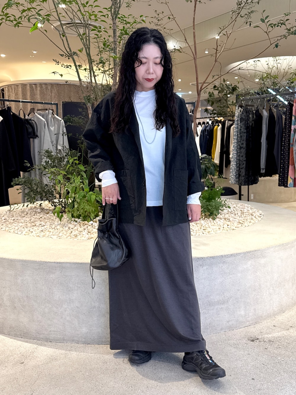 ホワイト系のTシャツ/カットソー、ブラック系のその他アウター、グレー系のスカートを着用したレディースの秋コーディネートの4枚目の写真