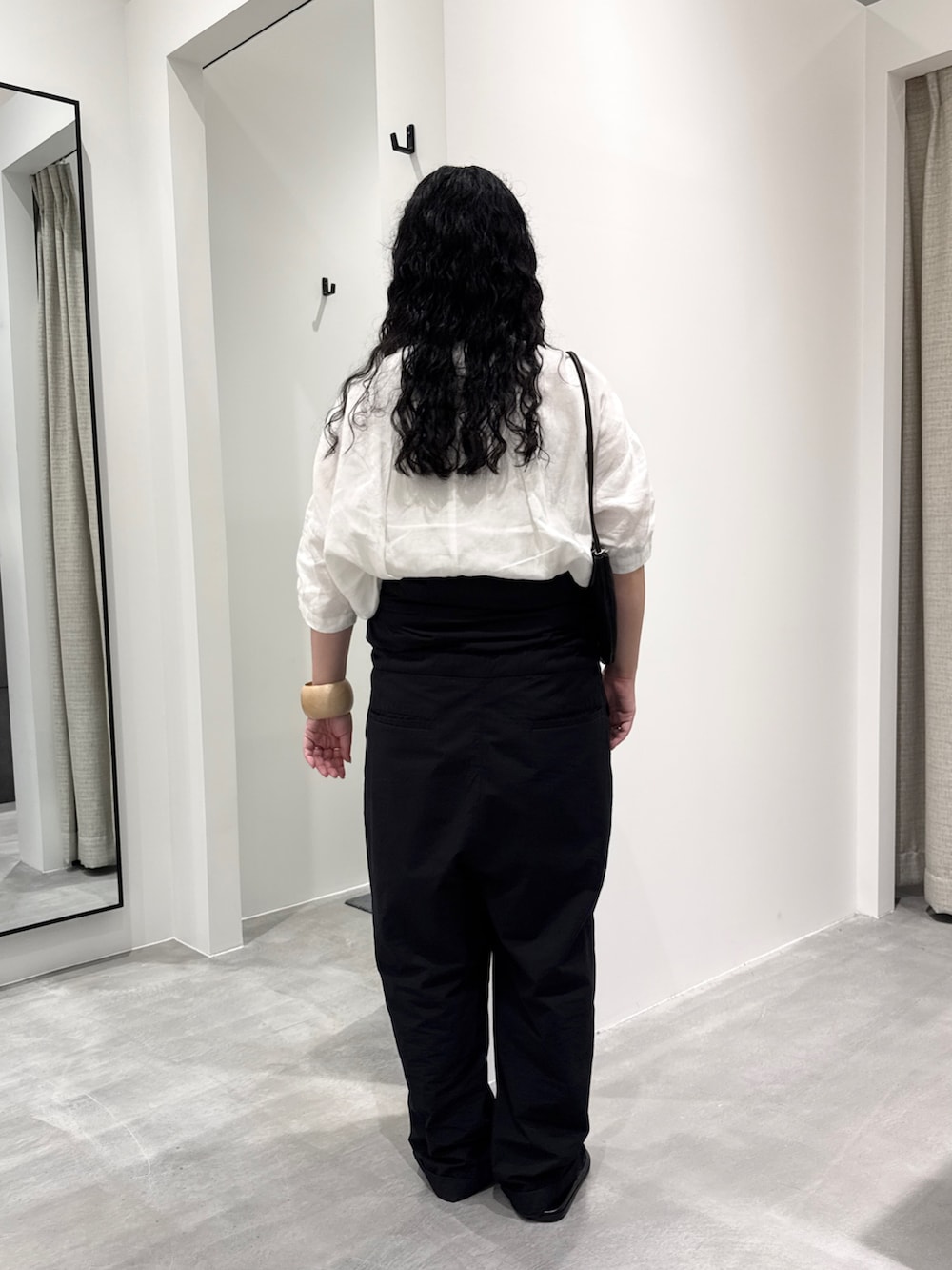 ホワイト系のシャツ/ブラウス、ブラック系のハンドバッグ、ブラック系のサロペット/オーバーオールを着用したレディースの春コーディネートの3枚目の写真