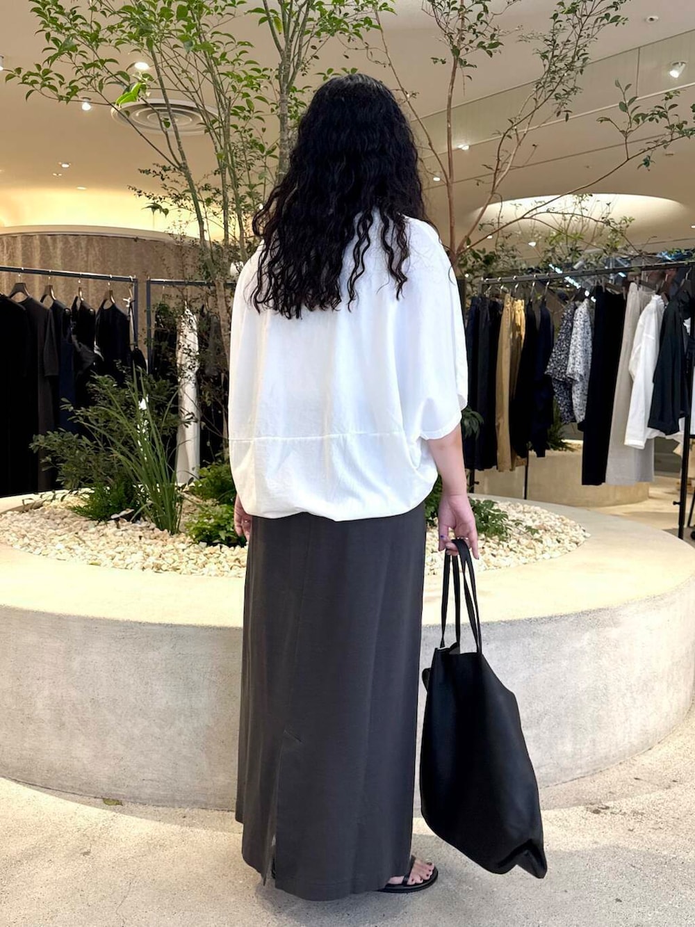 ホワイト系のTシャツ/カットソー、グレー系のスカート、ブラック系のバッグを着用したレディースの夏コーディネートの3枚目の写真