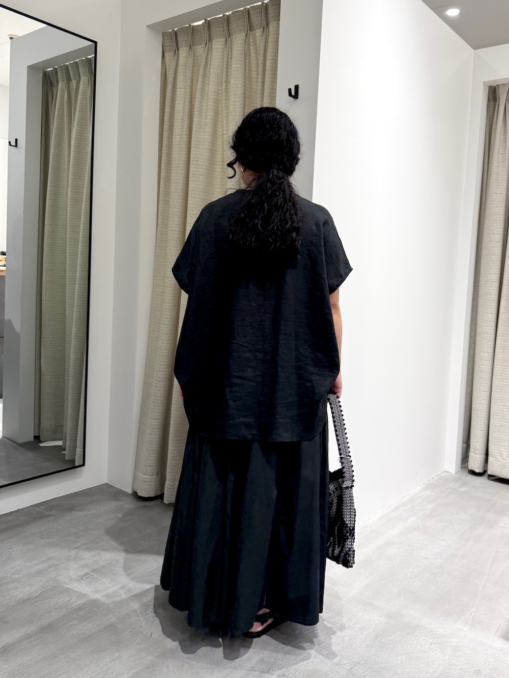 ブラック系のシャツ/ブラウス、ブラック系のスカート、ブラック系のショルダーバッグを着用したレディースの夏コーディネートの3枚目の写真