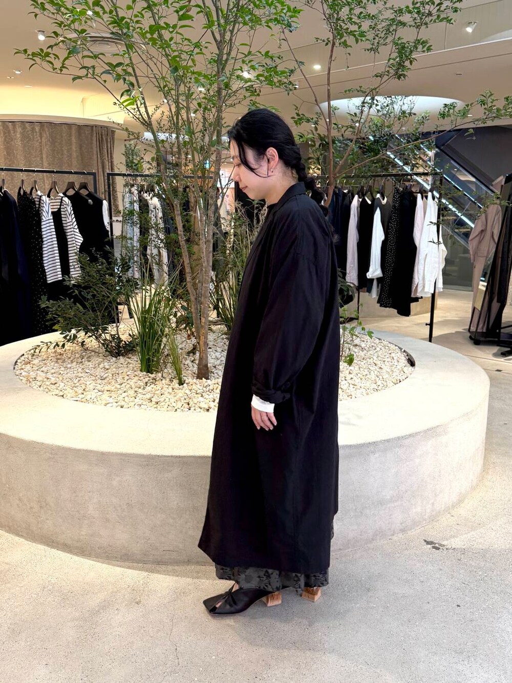 ブラック系のニット/セーター、ホワイト系のTシャツ/カットソー、ブラック系のその他アウターを着用したレディースの春コーディネートの2枚目の写真