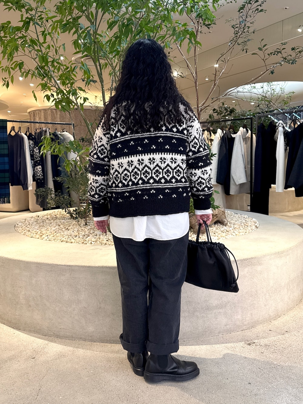 ブラック系のデニムパンツ、ブラック系のカーディガン/ボレロ、ホワイト系のシャツ/ブラウスを着用したレディースの秋コーディネートの2枚目の写真