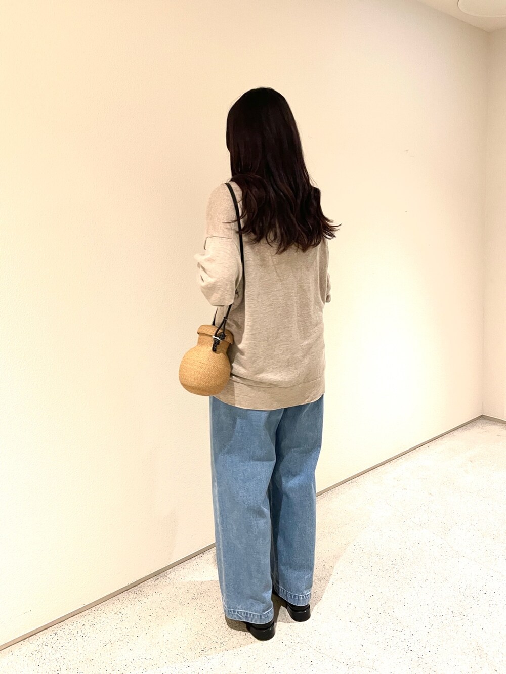 ベージュ系のカーディガン/ボレロ、ブルー系のデニムパンツ、ベージュ系のショルダーバッグを着用したレディースの夏コーディネートの2枚目の写真