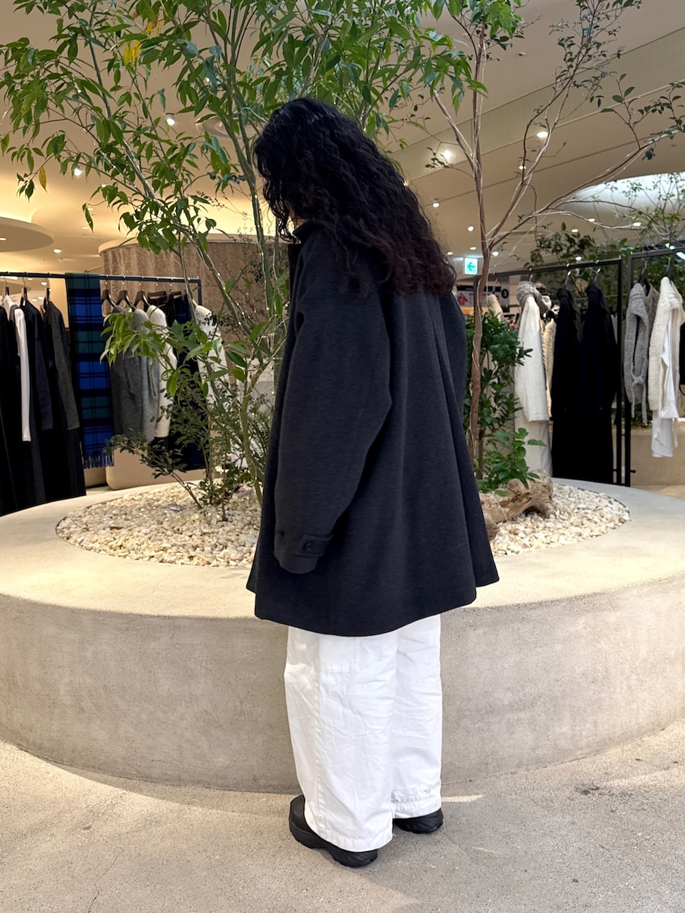 ブラック系のバッグ、グリーン系のステンカラーコート、ブルー系のその他トップスを着用したレディースの冬コーディネートの4枚目の写真