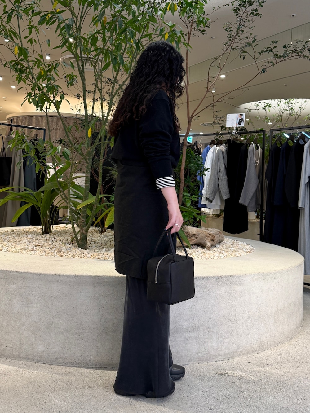 ブラック系のニット/セーター、ブラック系のTシャツ/カットソー、ブラック系のスカートを着用したレディースの冬コーディネートの2枚目の写真