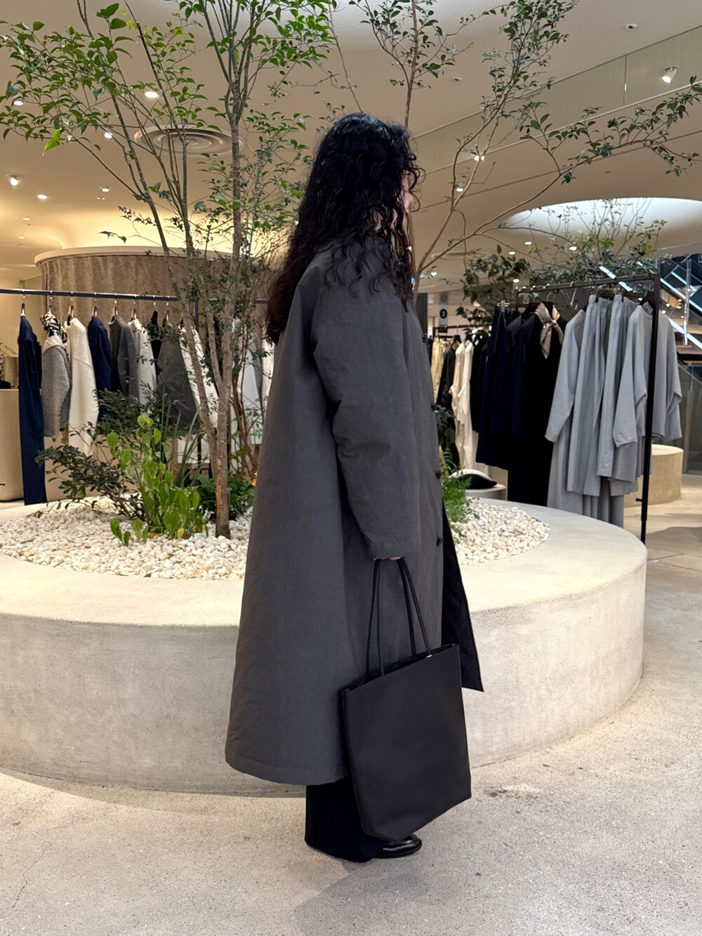 ブラック系のトートバッグ、グレー系のダウンジャケット/コートを着用したレディースの秋コーディネートの2枚目の写真