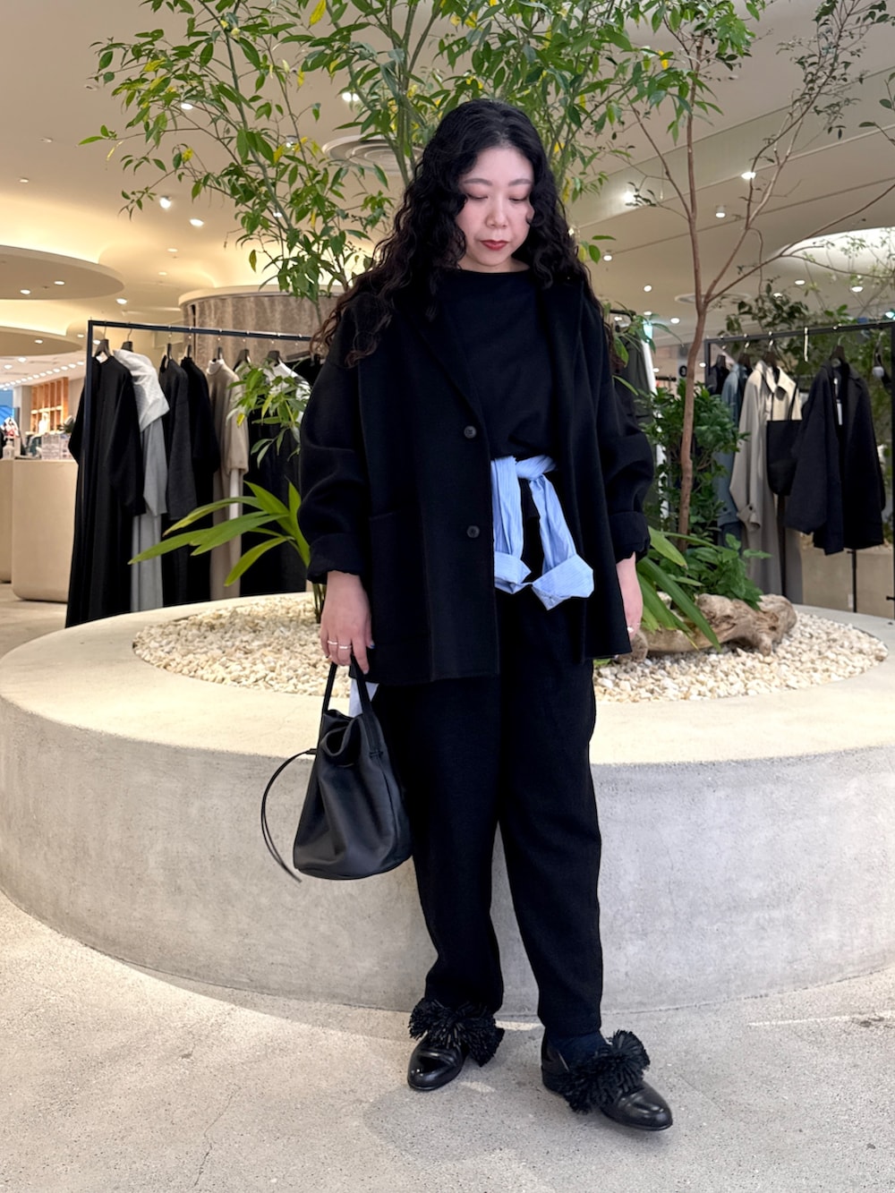 ブラック系のバッグ、ブラック系のその他アウター、ブラック系のTシャツ/カットソーを着用したレディースの冬コーディネートの5枚目の写真