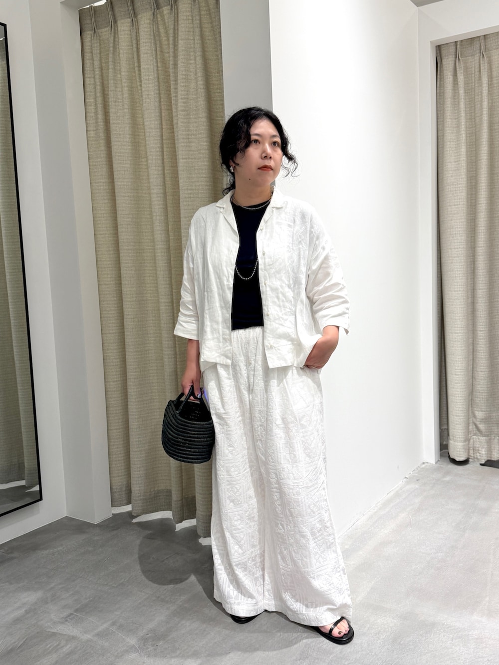 ホワイト系のシャツ/ブラウス、ホワイト系のその他パンツ、ブラック系のかごバッグを着用したレディースの夏コーディネートの5枚目の写真