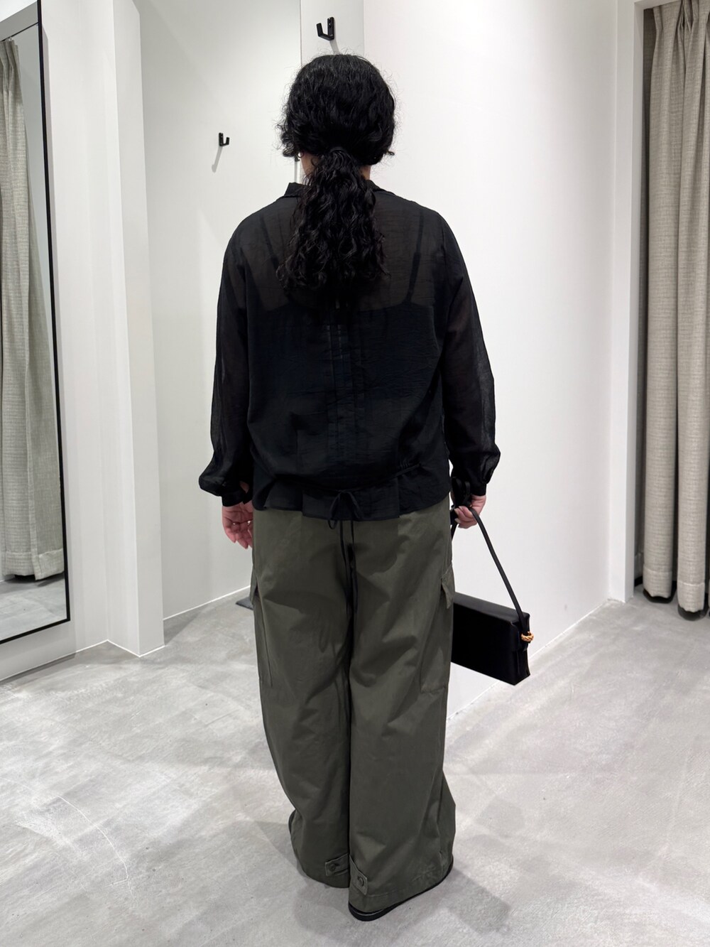 ブラック系のサンダル、ブラック系のシャツ/ブラウス、ブラック系のバッグを着用したレディースの春コーディネートの3枚目の写真