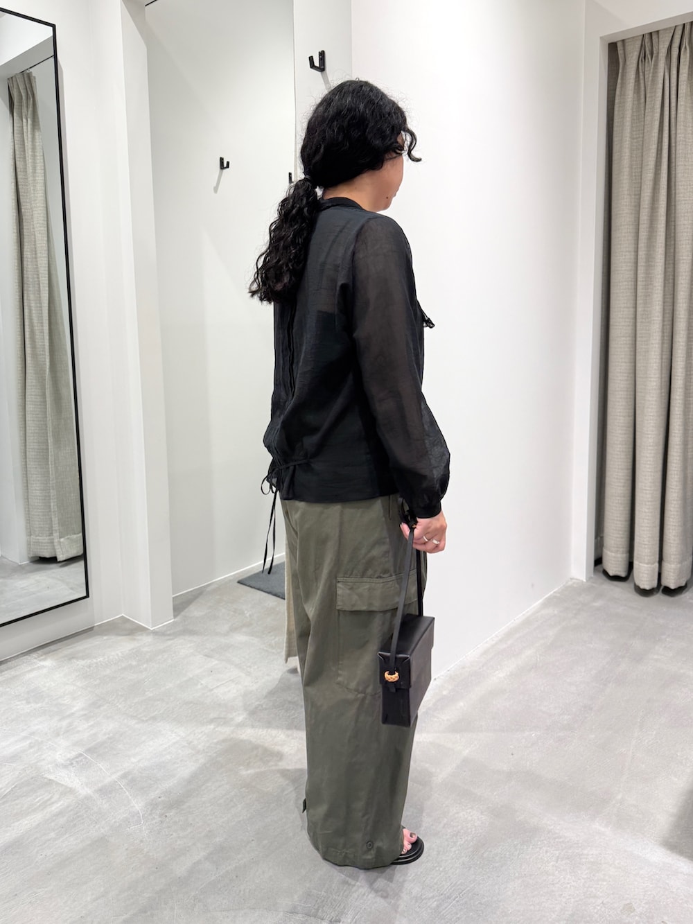 ブラック系のサンダル、ブラック系のシャツ/ブラウス、ブラック系のバッグを着用したレディースの春コーディネートの2枚目の写真