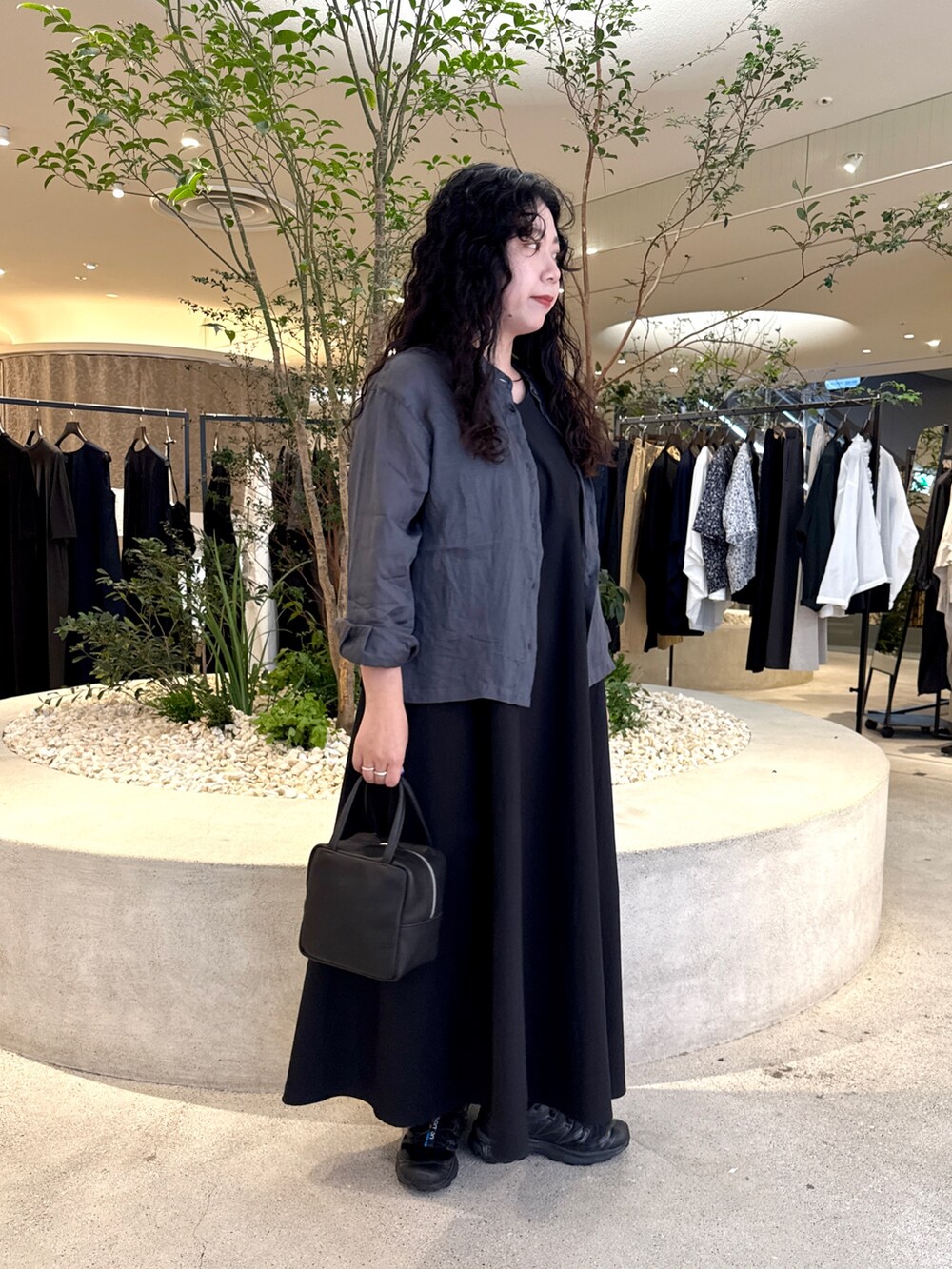 ブラック系のワンピース、ブラック系のバッグ、ブラック系のシャツ/ブラウスを着用したレディースの夏コーディネートの2枚目の写真