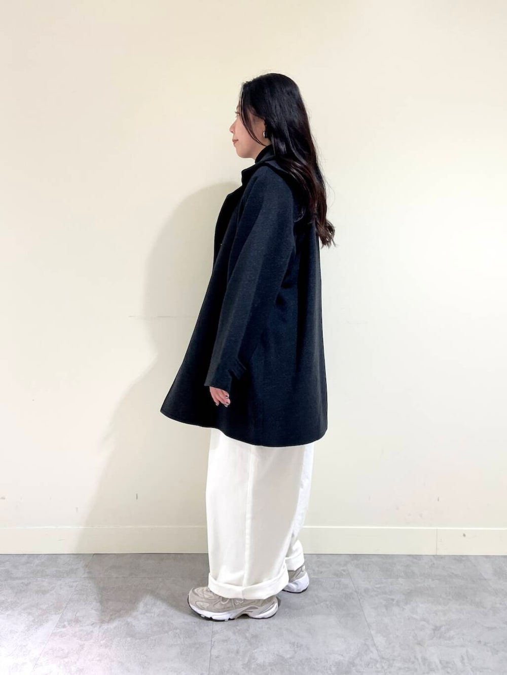 グレー系のピーコート、ホワイト系のサロペット/オーバーオール、ブラック系のTシャツ/カットソーを着用したレディースの秋コーディネートの3枚目の写真