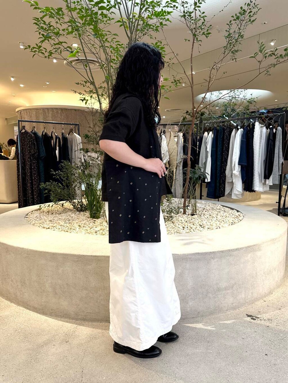 ホワイト系のスカート、ブラック系のシャツ/ブラウスを着用したレディースの春コーディネートの2枚目の写真