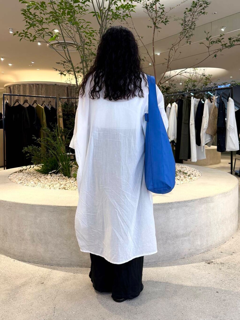 ブラック系のその他パンツ、ブラック系のサンダル、ブルー系のトートバッグを着用したレディースの夏コーディネートの3枚目の写真