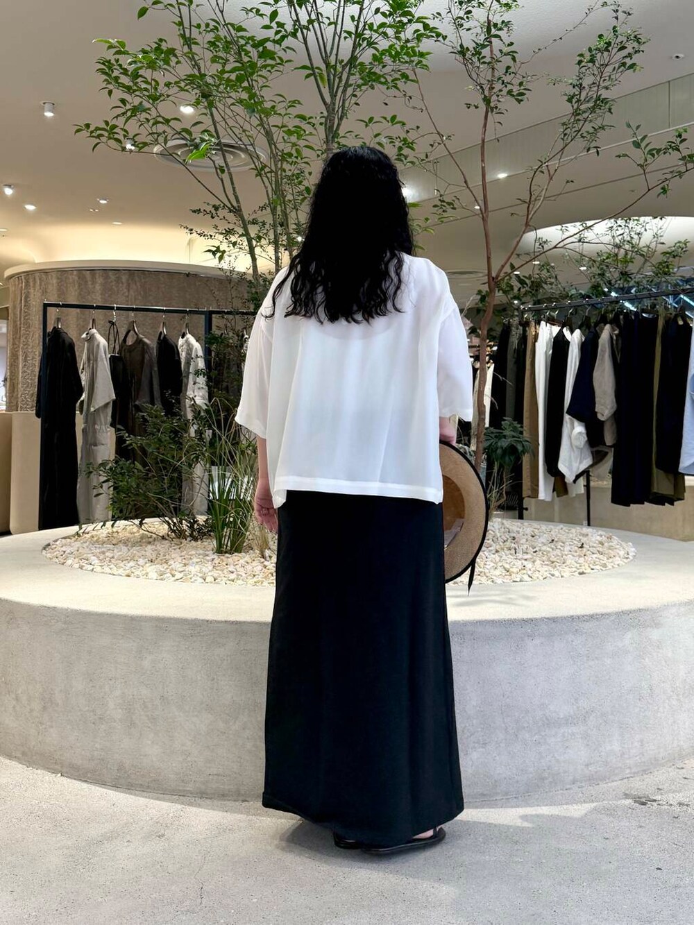 ブラック系のスカート、ホワイト系のTシャツ/カットソーを着用したレディースの夏コーディネートの3枚目の写真