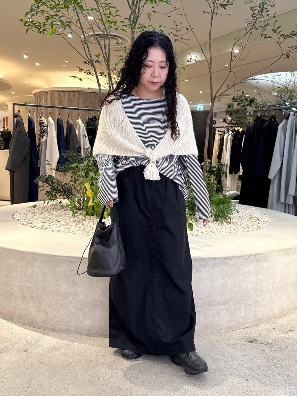 ブラック系のバッグ、ブラック系のTシャツ/カットソー、ブラック系のスカートを着用したレディースの秋コーディネートの4枚目の写真