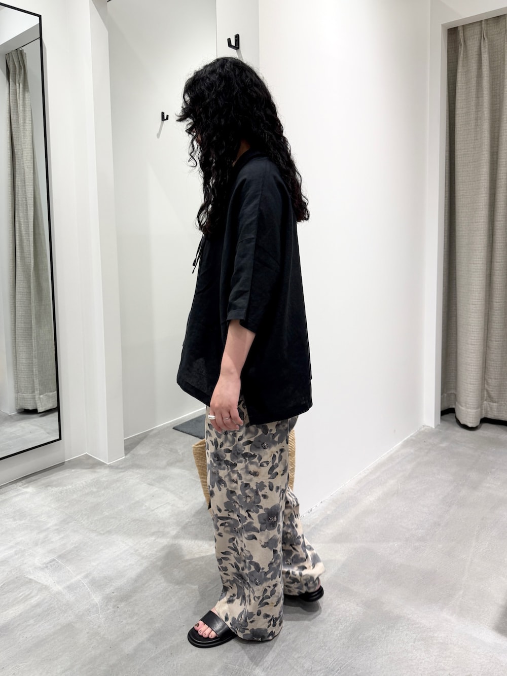 グレー系のその他パンツ、ベージュ系のかごバッグ、ブラック系のサンダルを着用したレディースの春コーディネートの3枚目の写真