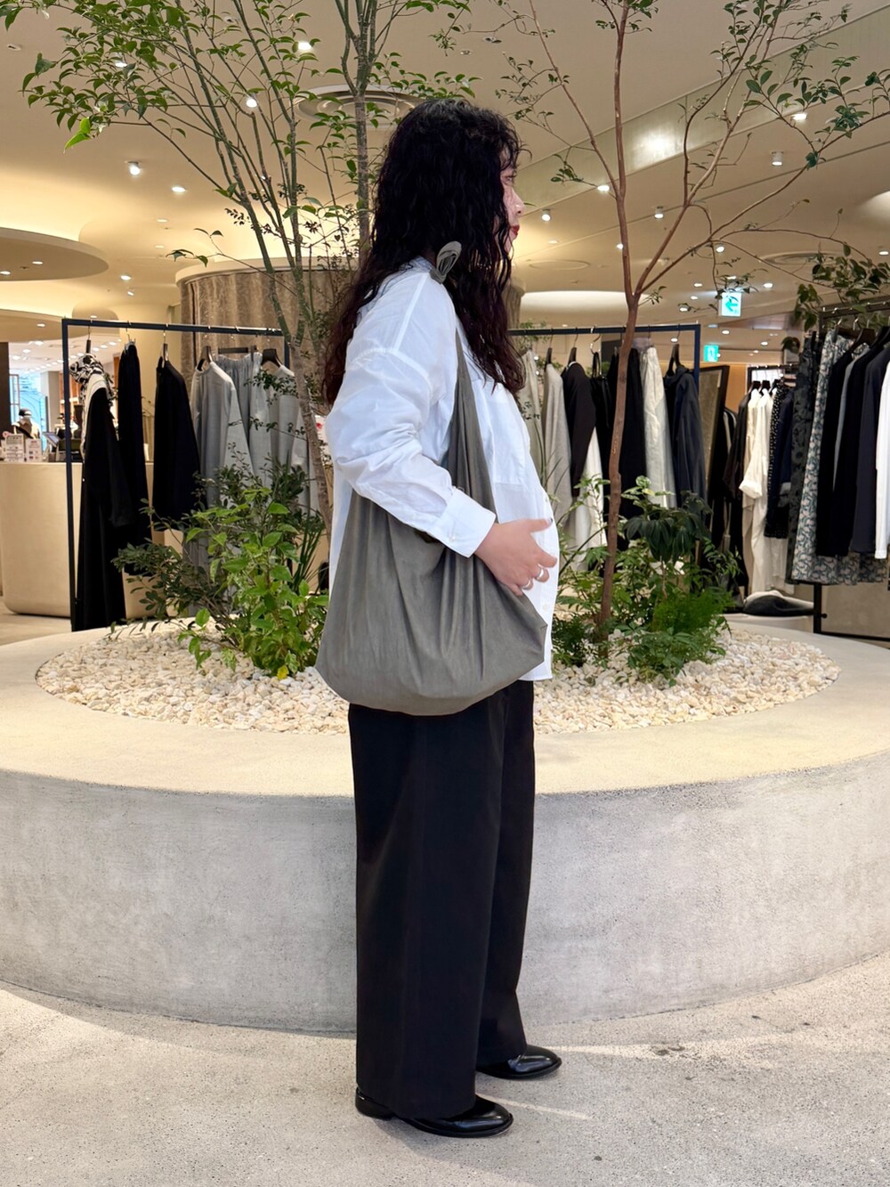 グレー系のショルダーバッグ、ホワイト系のシャツ/ブラウス、ブラック系のTシャツ/カットソーを着用したレディースの秋コーディネートの2枚目の写真