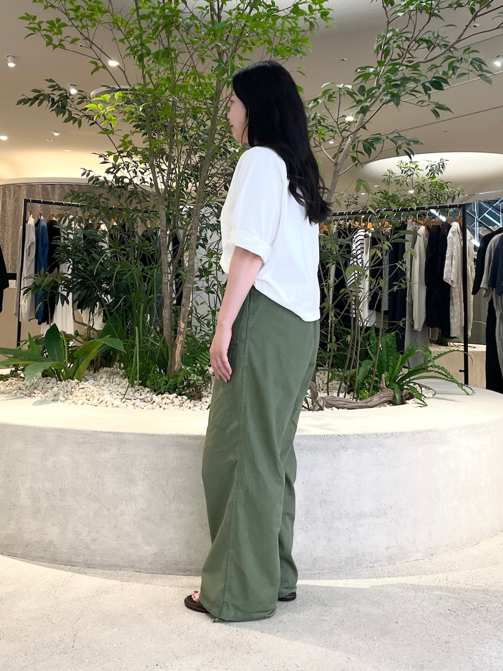 グリーン系のカーゴパンツ、ホワイト系のTシャツ/カットソー、ブラウン系のサンダルを着用したレディースの夏コーディネートの2枚目の写真