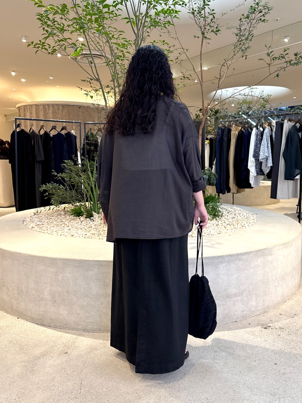 ブラック系のシャツ/ブラウス、ブラック系のスカート、ブラック系のショルダーバッグを着用したレディースの夏コーディネートの3枚目の写真