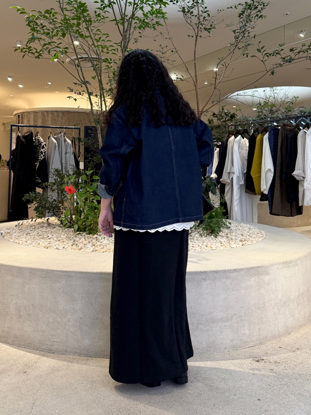 ブルー系のカバーオール、ブラック系のショルダーバッグ、ブラック系のスカートを着用したレディースの秋コーディネートの3枚目の写真