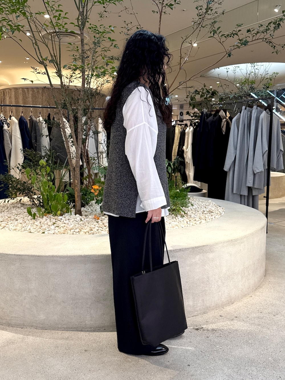 ホワイト系のシャツ/ブラウス、グレー系のニット/セーター、ブルー系のその他パンツを着用したレディースの秋コーディネートの3枚目の写真