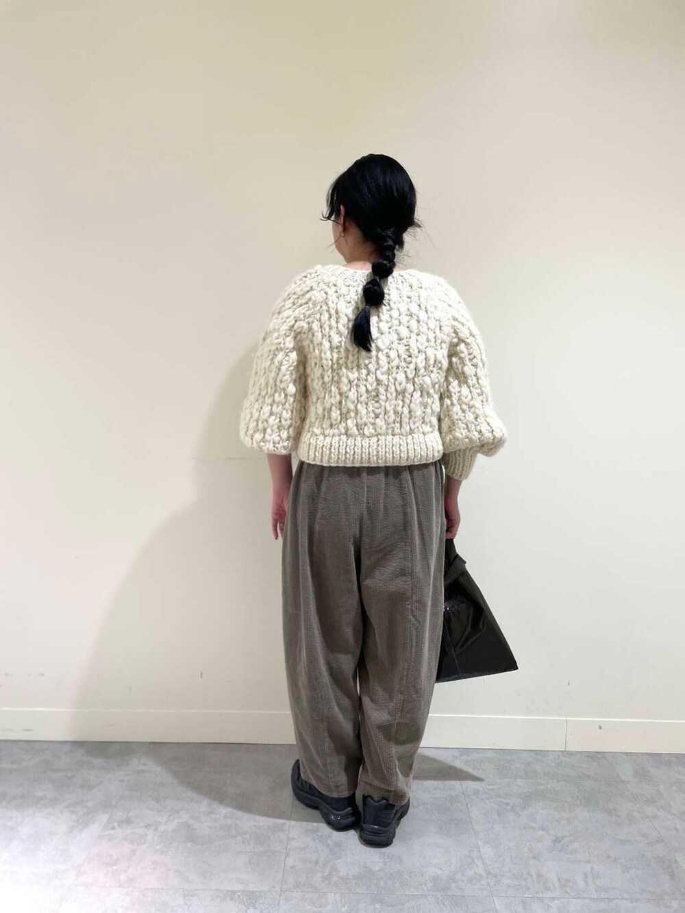 ホワイト系のカーディガン/ボレロ、グレー系のその他パンツ、ブラウン系のトートバッグを着用したレディースの冬コーディネートの3枚目の写真