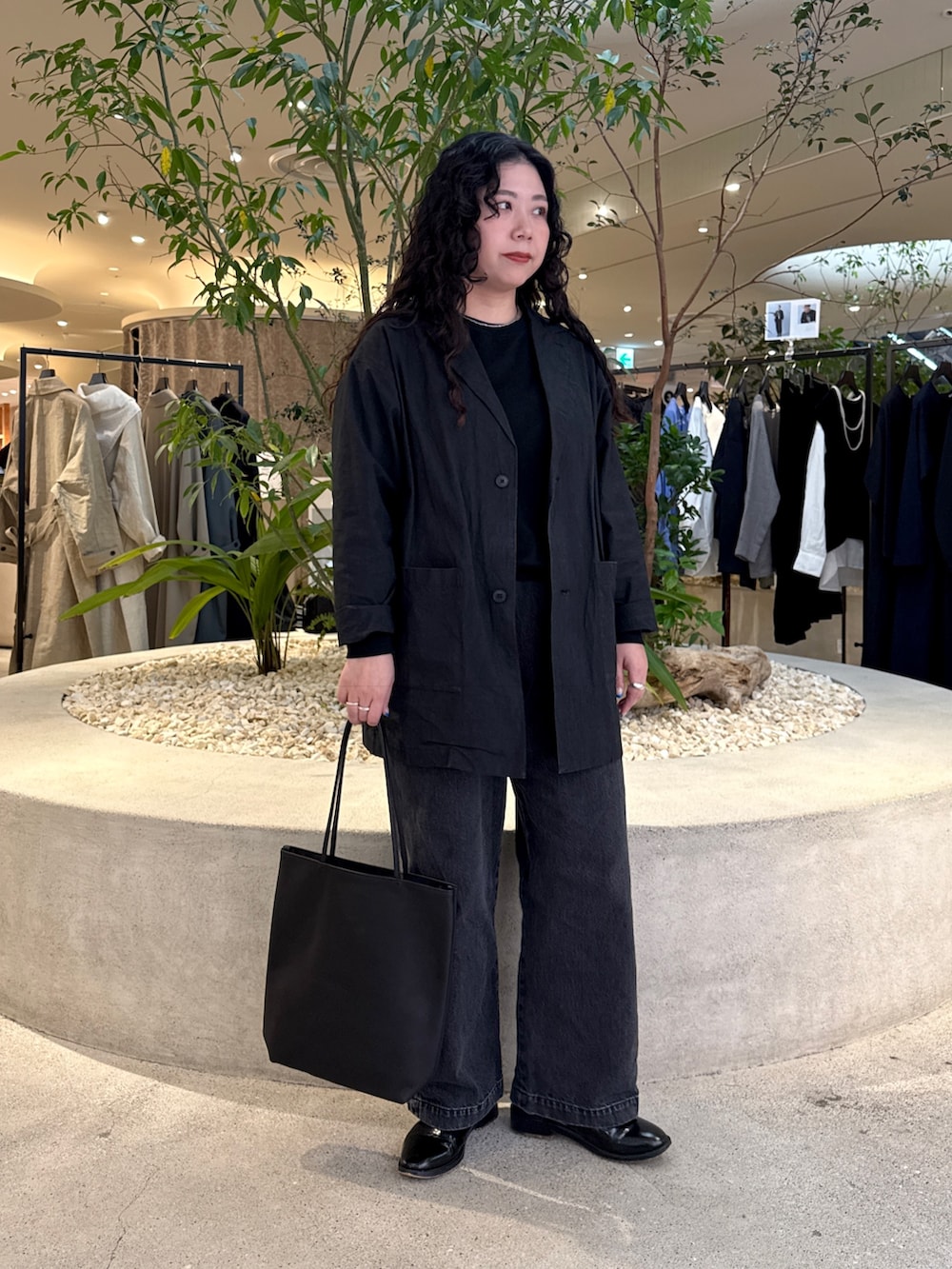 ブラック系のTシャツ/カットソー、ブラック系のデニムパンツ、ブラック系のトートバッグを着用したレディースの冬コーディネートの5枚目の写真