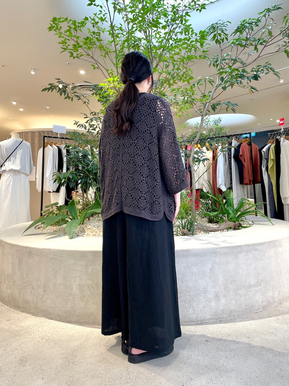 ブラック系のニット/セーター、ブラック系のサロペット/オーバーオール、ブラック系のサンダルを着用したレディースの夏コーディネートの2枚目の写真