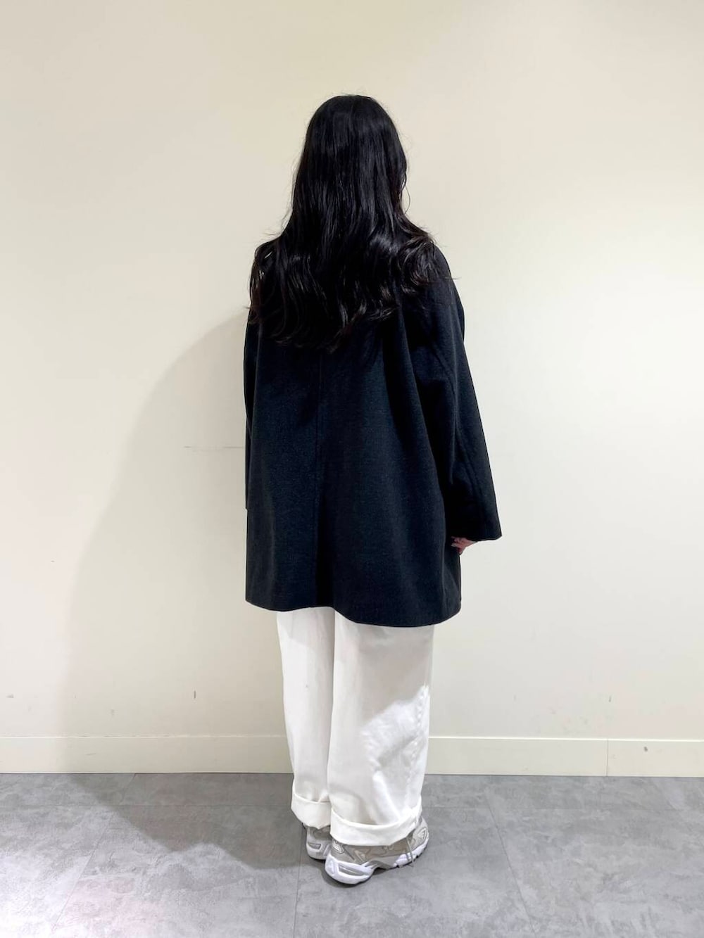 グレー系のピーコート、ホワイト系のサロペット/オーバーオール、ブラック系のTシャツ/カットソーを着用したレディースの秋コーディネートの4枚目の写真