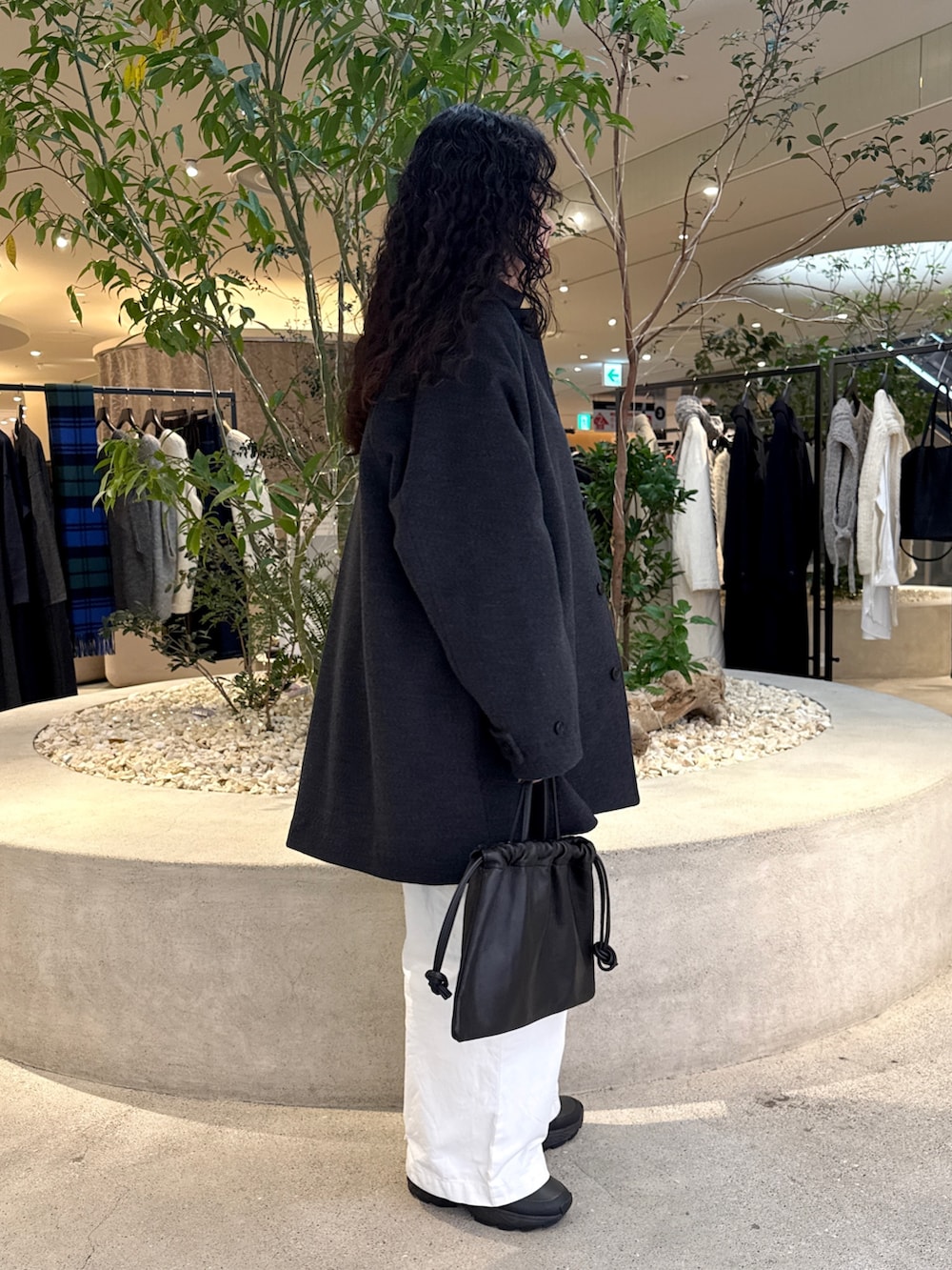 ブラック系のバッグ、グリーン系のステンカラーコート、ブルー系のその他トップスを着用したレディースの冬コーディネートの2枚目の写真