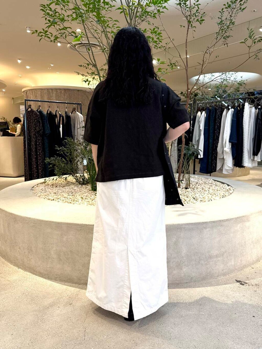 ホワイト系のスカート、ブラック系のシャツ/ブラウスを着用したレディースの春コーディネートの3枚目の写真