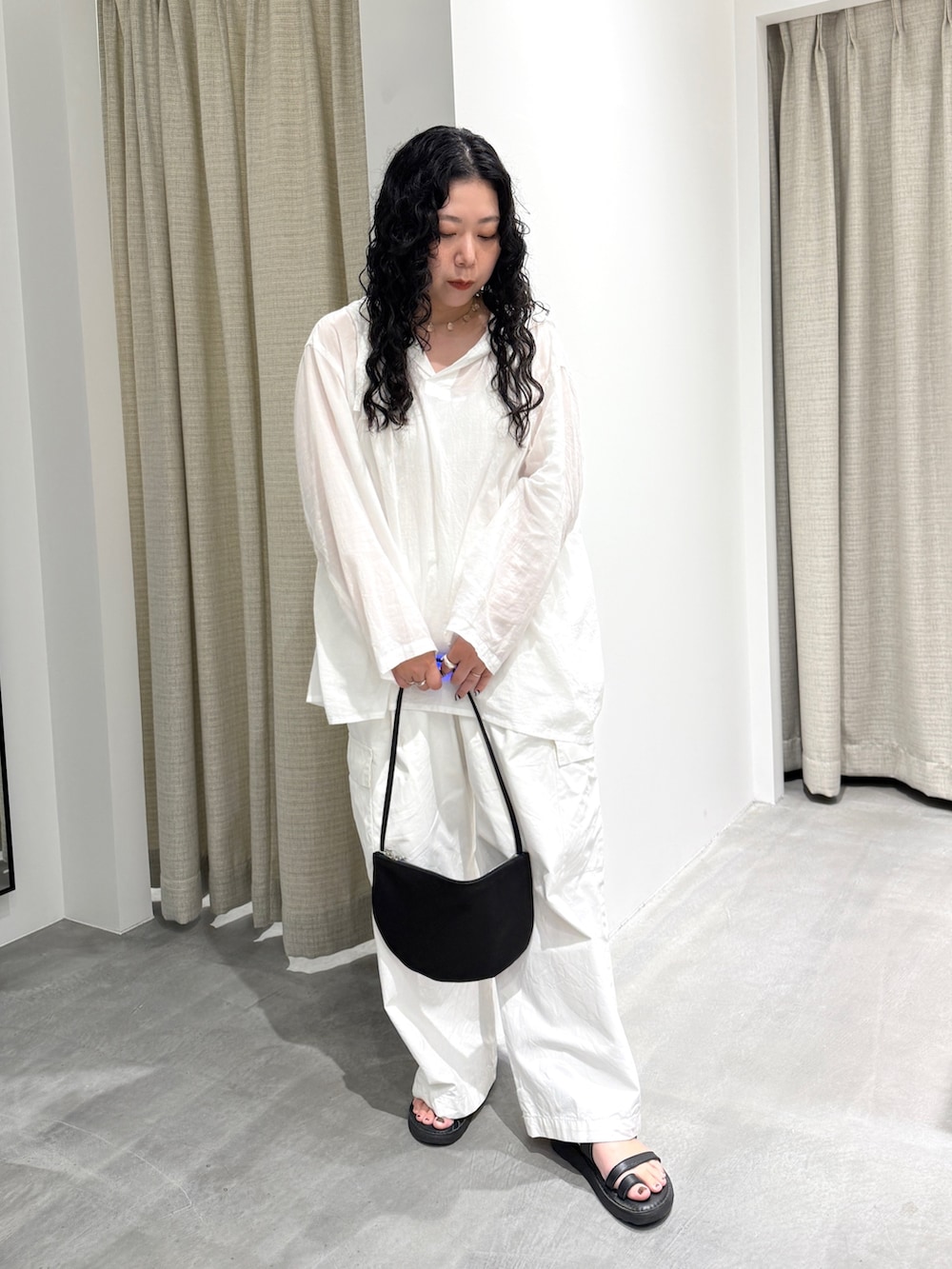 ホワイト系のシャツ/ブラウス、ホワイト系のその他パンツ、ブラック系のハンドバッグを着用したレディースの夏コーディネートの5枚目の写真