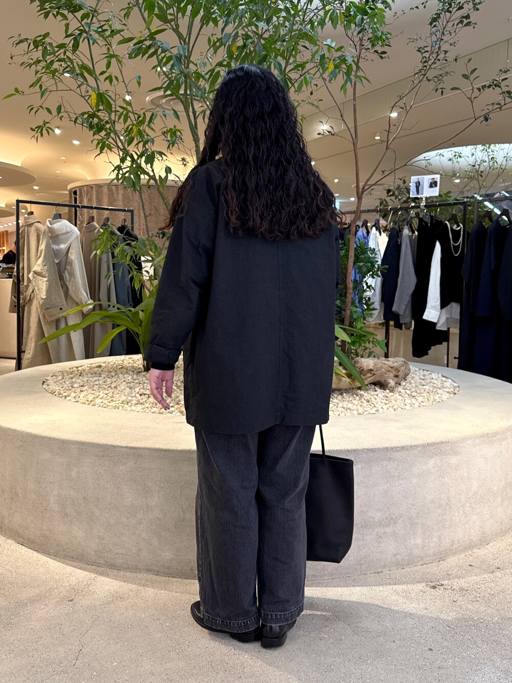 ブラック系のTシャツ/カットソー、ブラック系のデニムパンツ、ブラック系のトートバッグを着用したレディースの冬コーディネートの3枚目の写真