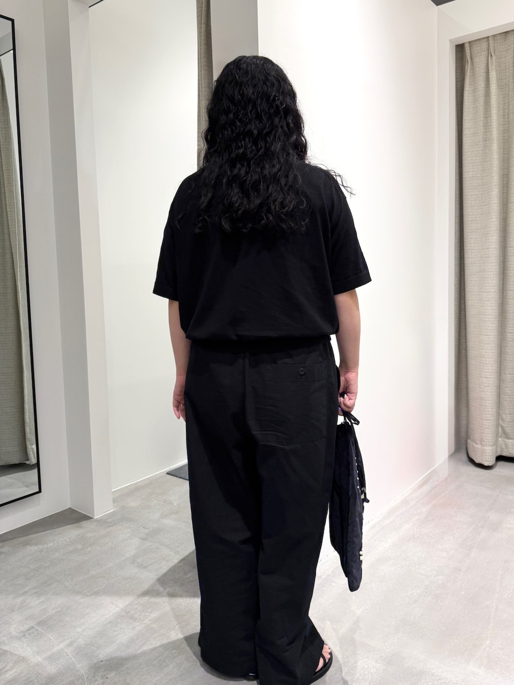 ブラック系のニット/セーター、ブラック系のその他パンツ、ブラック系のショルダーバッグを着用したレディースの夏コーディネートの3枚目の写真