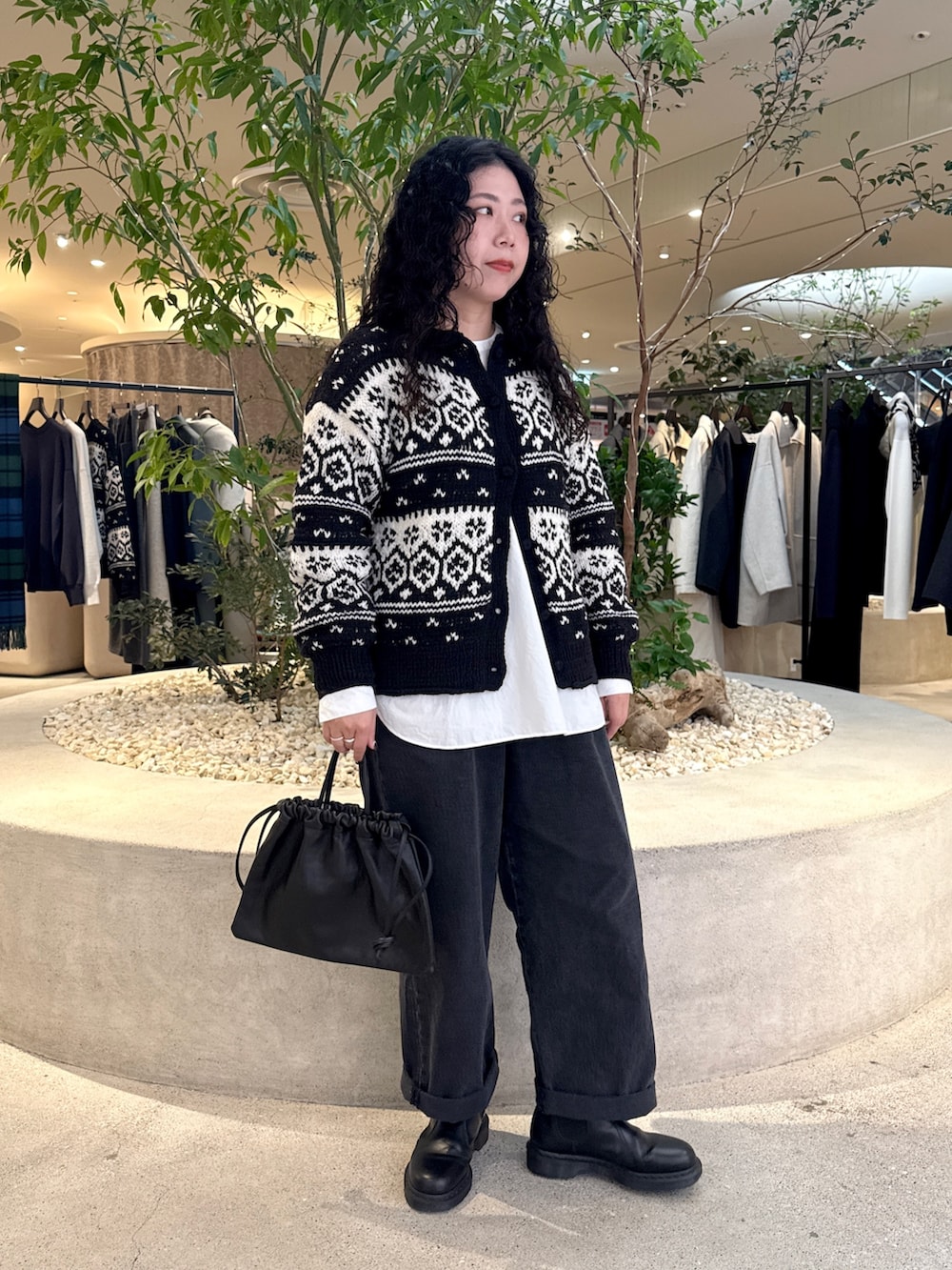 ブラック系のデニムパンツ、ブラック系のカーディガン/ボレロ、ホワイト系のシャツ/ブラウスを着用したレディースの秋コーディネートの4枚目の写真