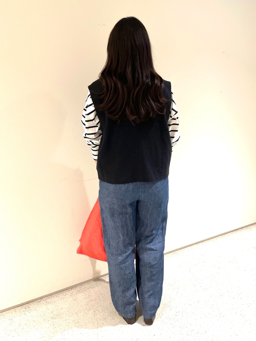 ブラック系のベスト、ホワイト系のTシャツ/カットソー、ブルー系のデニムパンツを着用したレディースの夏コーディネートの2枚目の写真