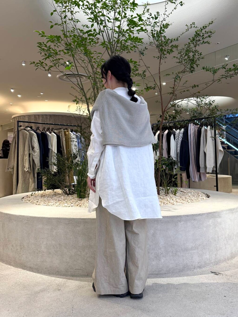 グレー系のニット/セーター、ホワイト系のシャツ/ブラウス、ベージュ系のその他パンツを着用したレディースの春コーディネートの3枚目の写真