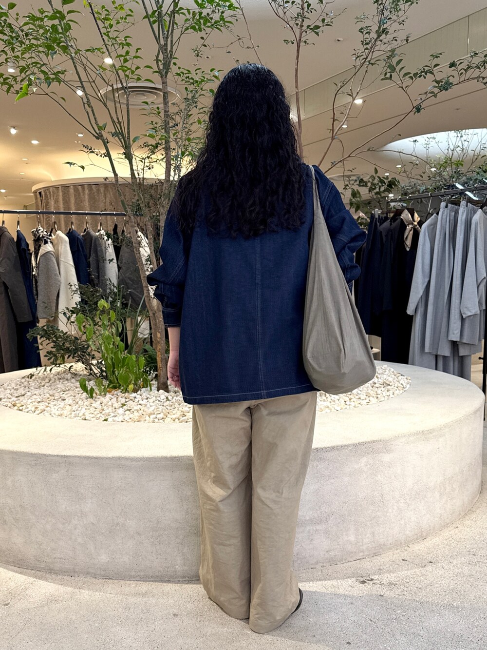 グレー系のショルダーバッグ、ベージュ系のその他パンツ、ブルー系のカバーオールを着用したレディースの秋コーディネートの3枚目の写真