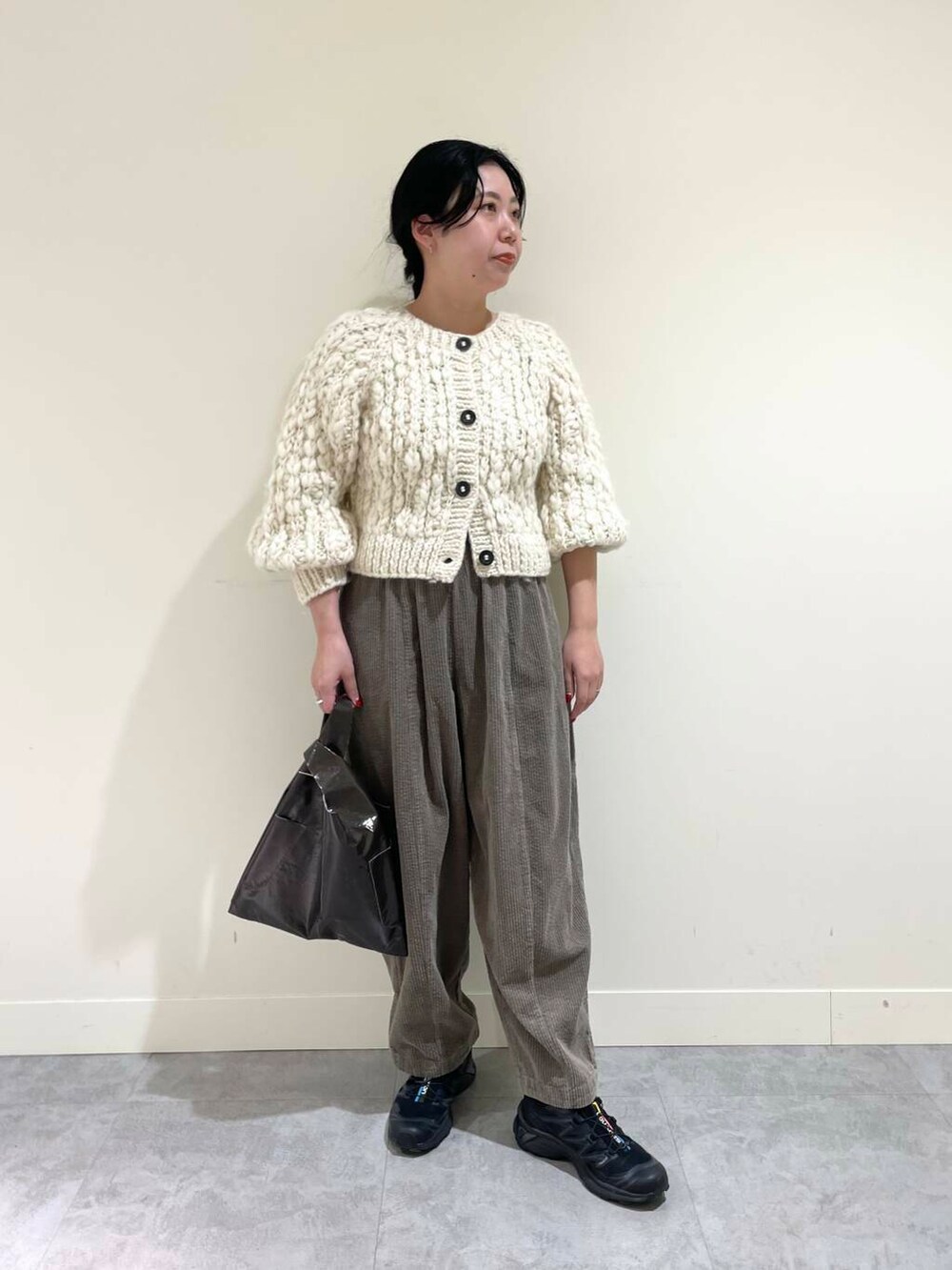 ホワイト系のカーディガン/ボレロ、グレー系のその他パンツ、ブラウン系のトートバッグを着用したレディースの冬コーディネートの2枚目の写真