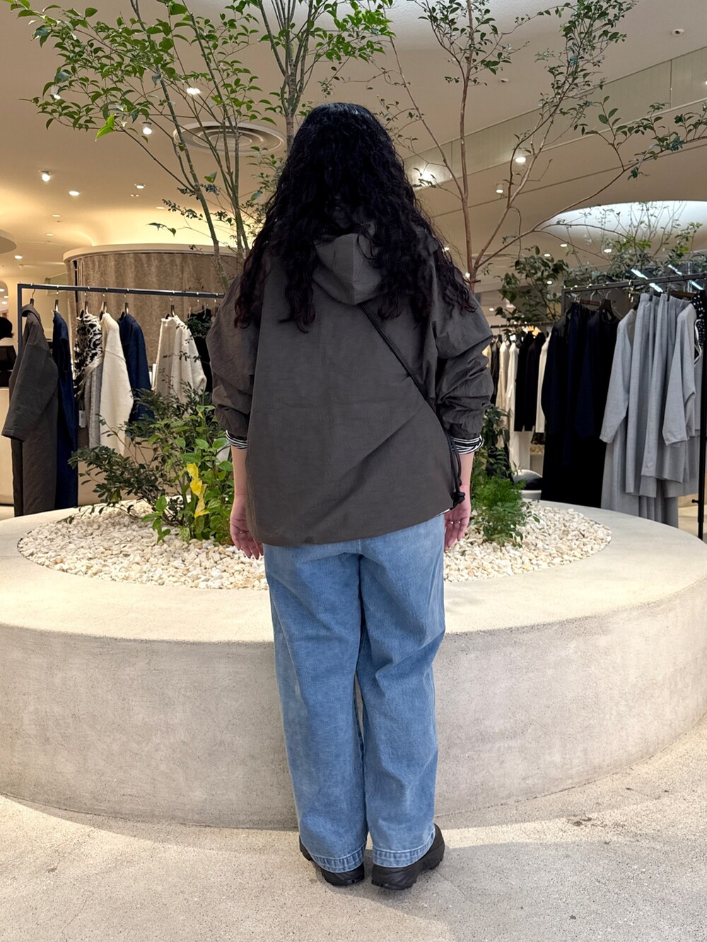 ブラック系のショルダーバッグ、ブルー系のデニムパンツ、グレー系のTシャツ/カットソーを着用したレディースの秋コーディネートの3枚目の写真