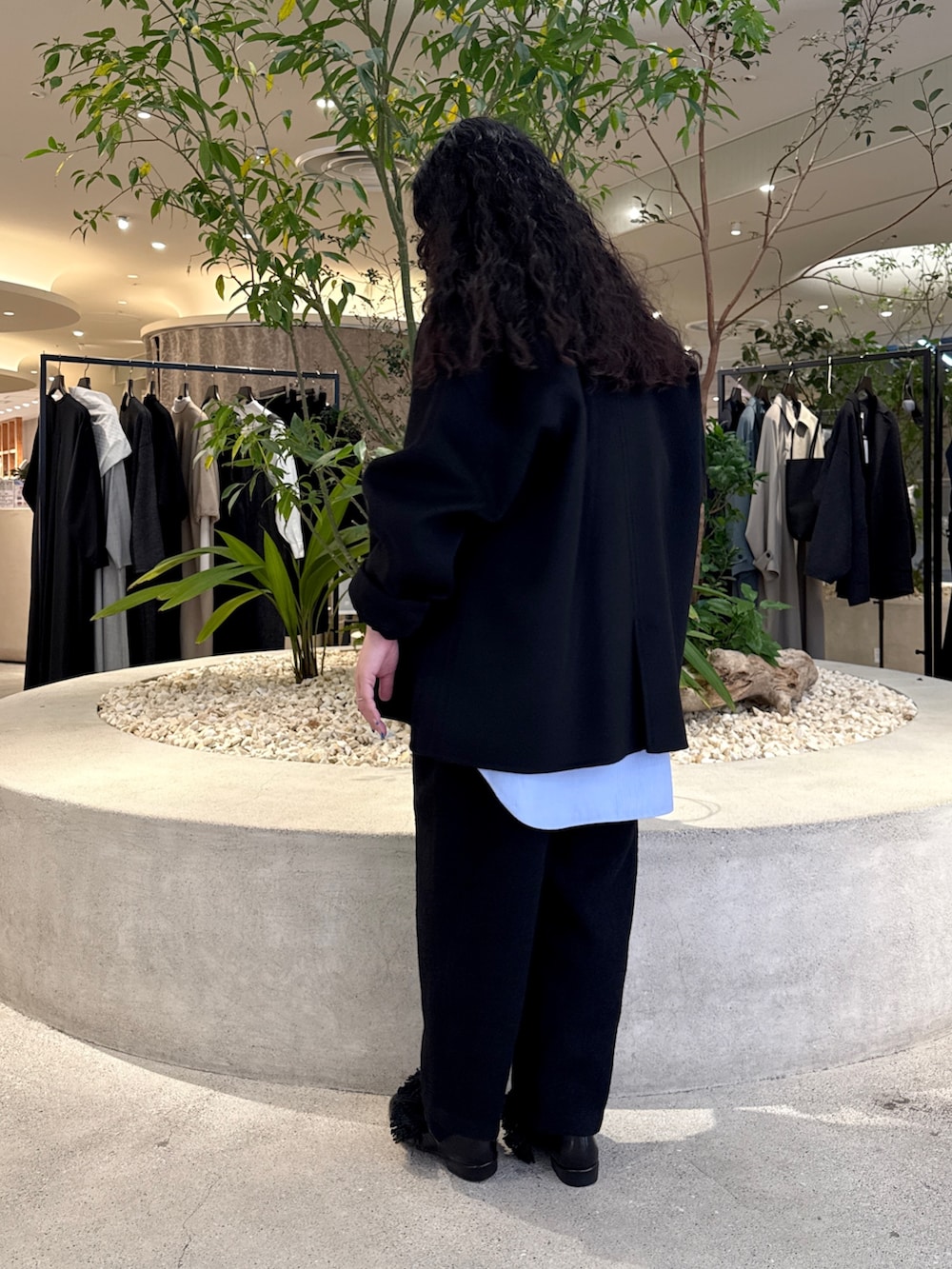 ブラック系のバッグ、ブラック系のその他アウター、ブラック系のTシャツ/カットソーを着用したレディースの冬コーディネートの4枚目の写真