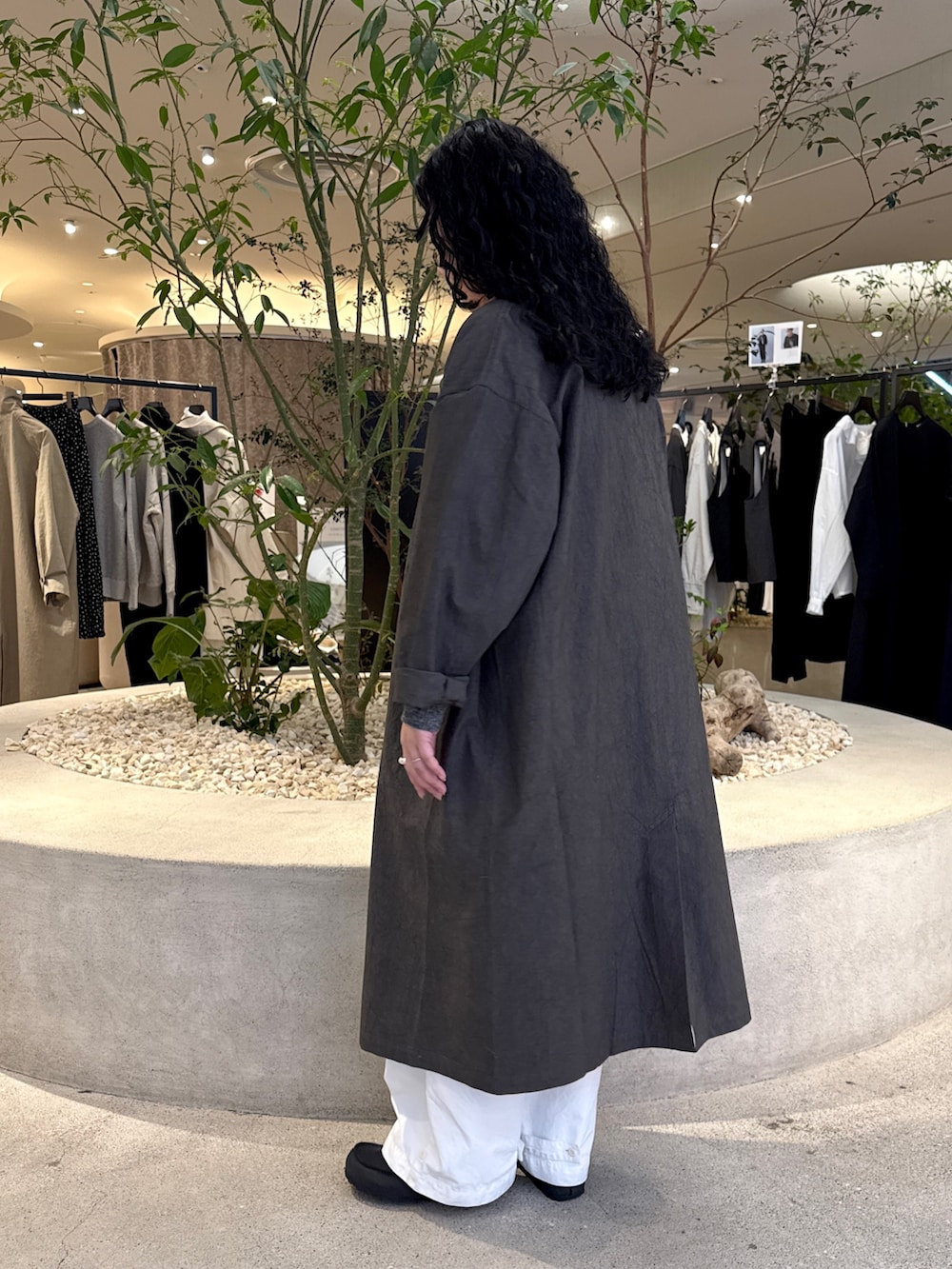 グレー系のニット/セーター、グレー系のその他アウター、ホワイト系のその他パンツを着用したレディースの冬コーディネートの4枚目の写真