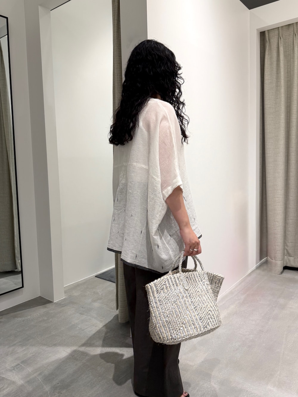 ホワイト系のシャツ/ブラウス、グレー系のその他パンツ、シルバー系のかごバッグを着用したレディースの春コーディネートの2枚目の写真