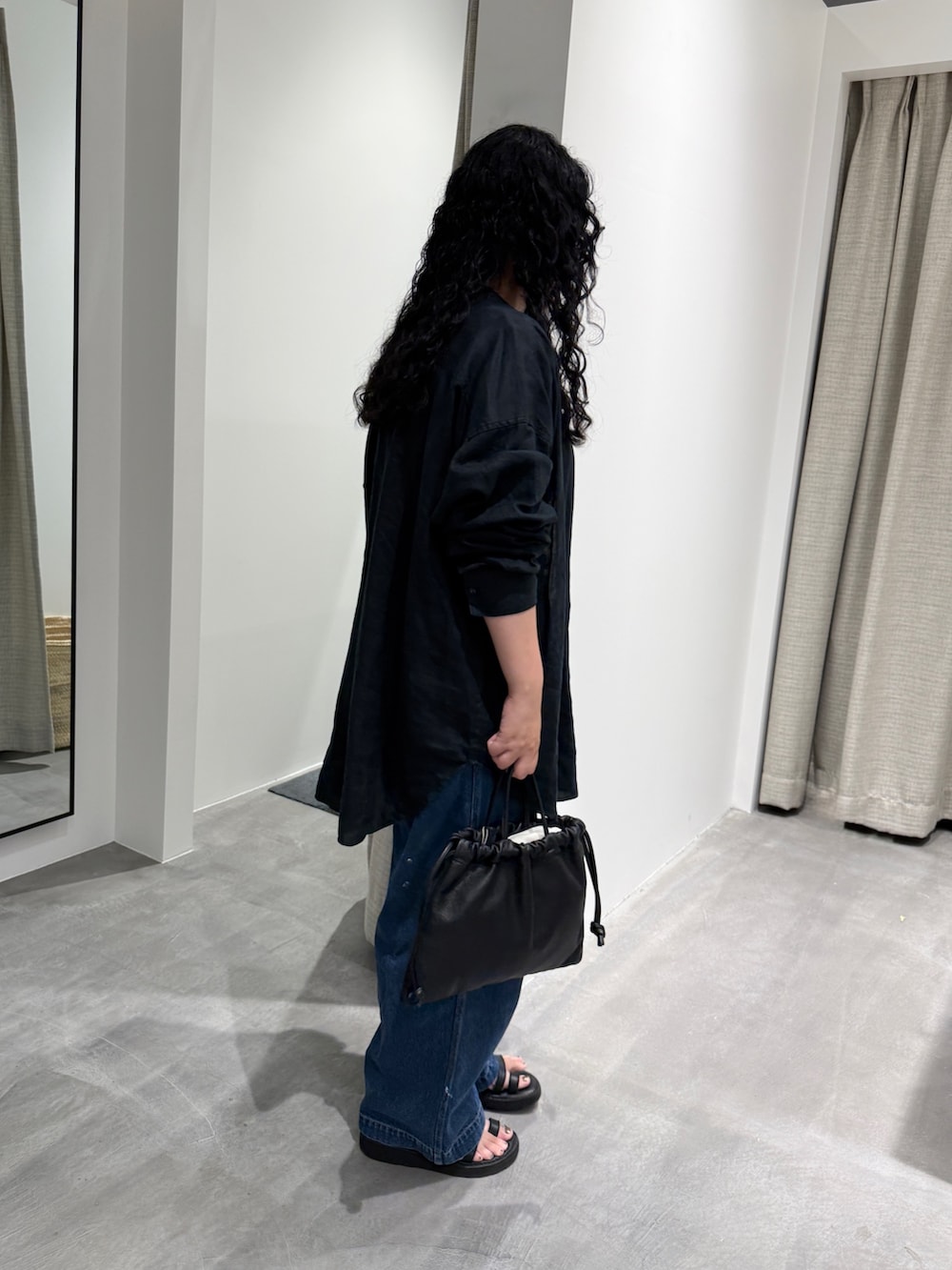 ブルー系のデニムパンツ、ブラック系のTシャツ/カットソー、シルバー系のネックレスを着用したレディースの夏コーディネートの2枚目の写真
